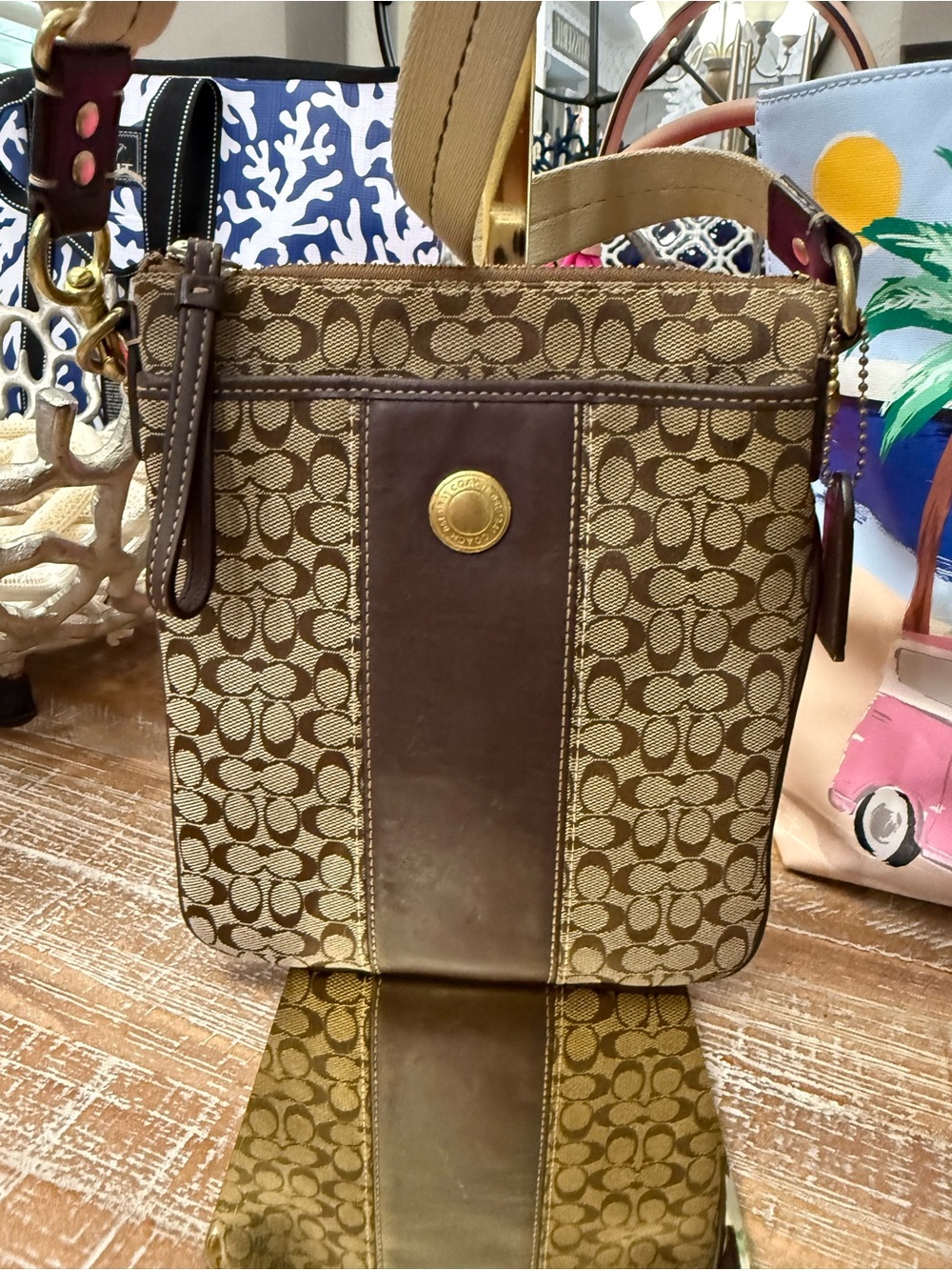 Coach Brown Signature Canvas Vertical Crossbody with Leather Trim, 9” x 7 1/2”.